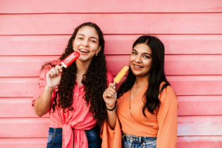 Girls eat ice popsicles to relieve tooth and gum pain from braces